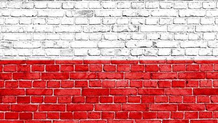 Brick wall painted in colours of Polish flag