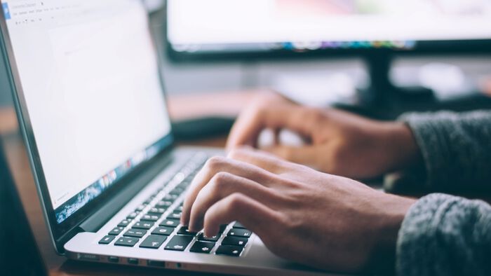 Hands writing on laptop
