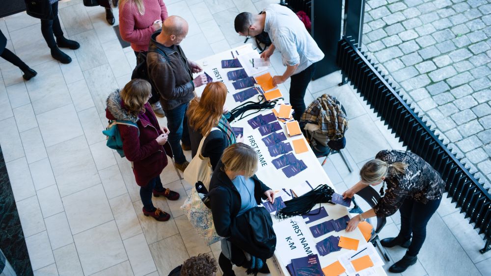 Folk som registrerer seg til konferanse